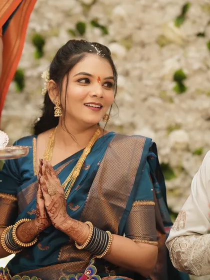 A candid photo of the bride during her engagement puja, looking serene and beautiful with natural-looking makeup.