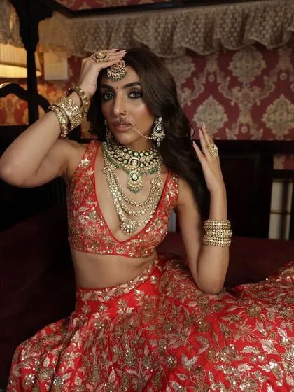 A final shot from this vintage series, capturing the bride's regal poise and the timeless appeal of a classic red lehenga.