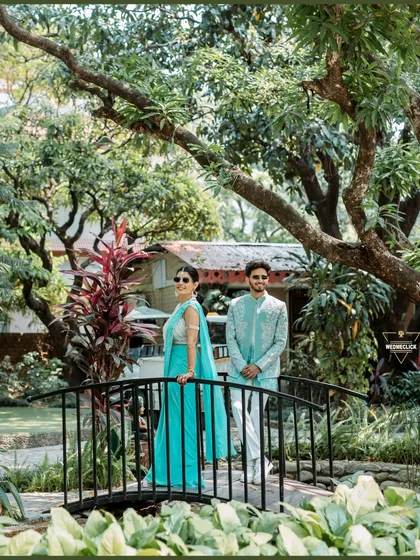 A stylish portrait of the couple on a bridge during their Haldi event, their modern outfits and sunglasses adding a cool vibe.