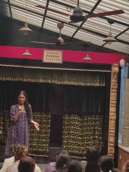 An interactive session with students at our puppet theater. A young participant takes the stage to share her thoughts, demonstrating the engaging and participatory nature of our educational programs.