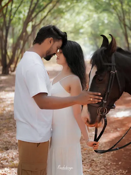 An intimate portrait of a couple with a horse, their foreheads touching in a moment of quiet connection with each other and nature.