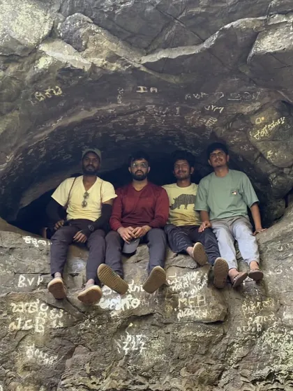 A group of friends taking a break inside a rock shelter.