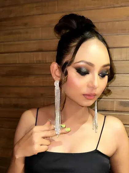 This angle highlights the dramatic tassel earrings that complement the bold eye makeup, showing my consideration for the overall styling of a look.
