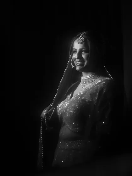 A beautiful black and white bridal portrait. The soft lighting and her gentle smile create a timeless and ethereal image.