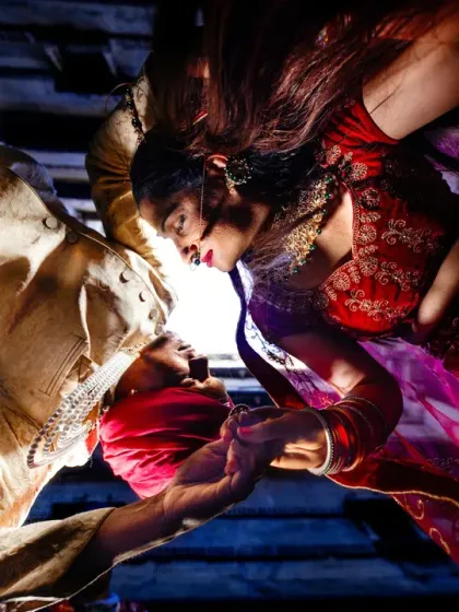 A uniquely framed intimate portrait from a heritage shoot. This creative angle captures a close, personal moment between the couple, using dramatic lighting to create a powerful and artistic image.