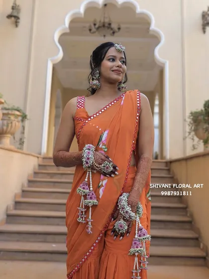 This bride looks elegant in an orange saree for her Haldi, paired with my handcrafted floral handcuffs and kalire in a beautiful pink and white combination.