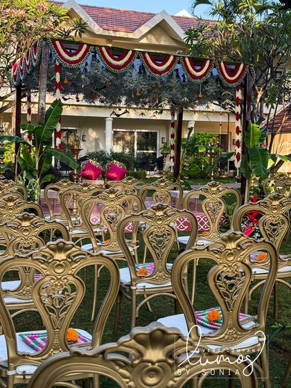 A view of the wedding seating arrangement, with ornate gold chairs leading up to the traditional mandap, ready for the ceremony to begin.
