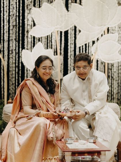 A beautiful portrait of the parents during a wedding ritual. Their coordinated outfits in soft, elegant tones reflect a sense of unity and quiet luxury.