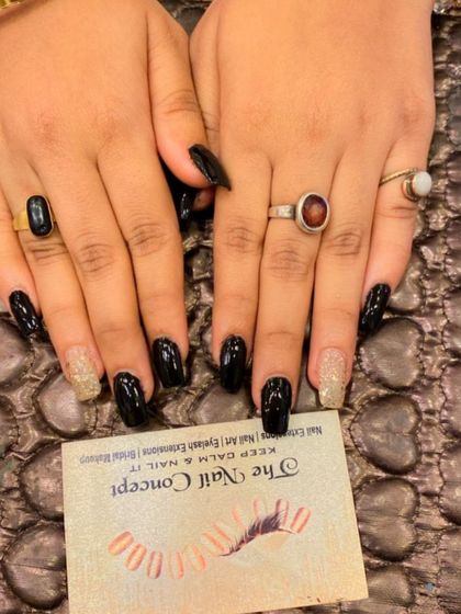 A simple yet bold set of glossy black square nails. The ring fingers are accented with a full coat of gold glitter for a touch of glamour.