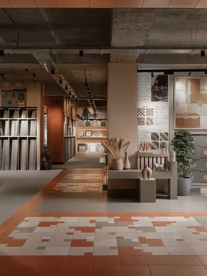 The entrance to the Trove experience center uses warm terracotta tiles on the walls and floor to guide visitors into the space. The architectural framing and material transitions are designed to create an immersive journey of discovery.