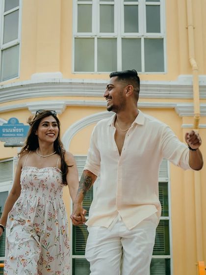 The vibrant yellow architecture of Old Town Phuket provides a stunning contrast for this happy, walking shot. It’s a perfect example of using local color to make pre-wedding photos pop.