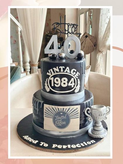 A "Vintage 1984 Aged to Perfection" two-tier cake in black and silver, perfect for a stylish 40th birthday.