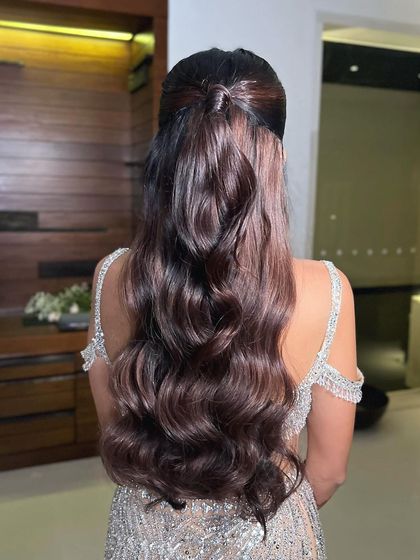 A back view of the half-ponytail with beautiful, cascading waves for a cocktail party.
