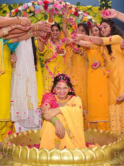 The bride's squad showering her with love and petals. This photo shows how my decor, like the floral arch and the golden urli, becomes the perfect stage for memorable moments.