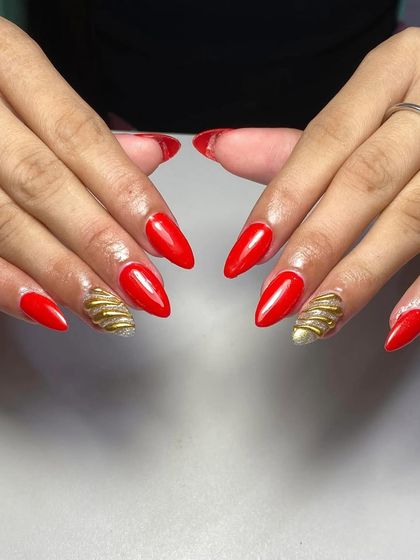 A bold red and gold set, featuring solid red nails and textured gold chrome accent nails. This is a powerful and luxurious color combination.