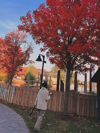 An autumn scene at Blue Mountain Village, with vibrant red maple leaves framing the shot.