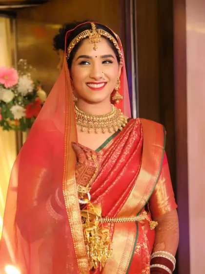 All smiles and all heart. This bride's joyful expression is the best accessory. Her makeup is soft and subtle, perfectly matching her red silk saree and traditional jewelry.