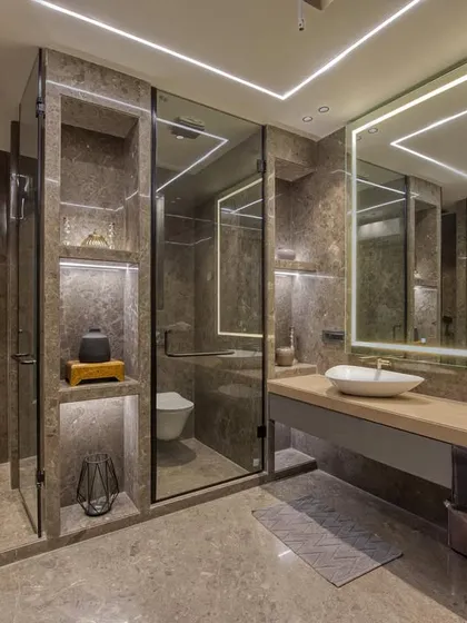 A wider view of the spa-like bathroom, showing the seamless glass doors of the shower and toilet compartments, which keep the space feeling open and uncluttered.