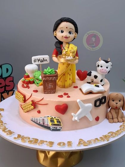 A cake for Rupali Ganguly to celebrate 5 years of her show "Anupamaa," featuring a custom figurine and elements that represent her character.