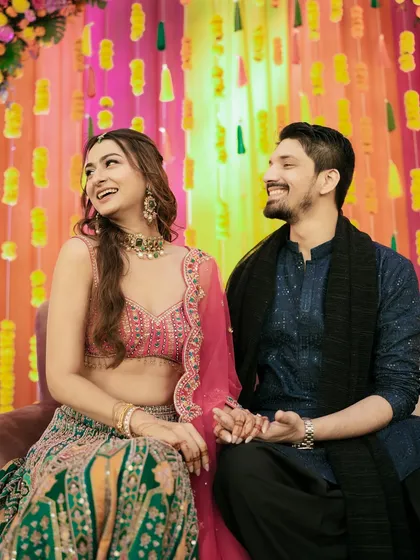 A shared laugh during the Mehndi ceremony. These are the candid, in-between moments that truly define your story.