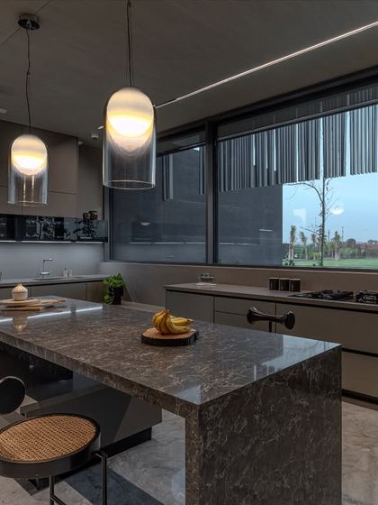 Expansive windows in this farmhouse kitchen draw in natural light and offer views of the surrounding landscape, making the space feel open and connected to the outdoors.