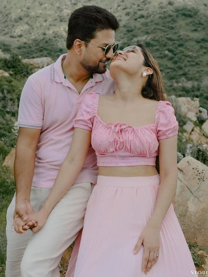A lovely portrait of a couple in matching pink tones, sharing an intimate moment during their pre-wedding shoot in Udaipur.