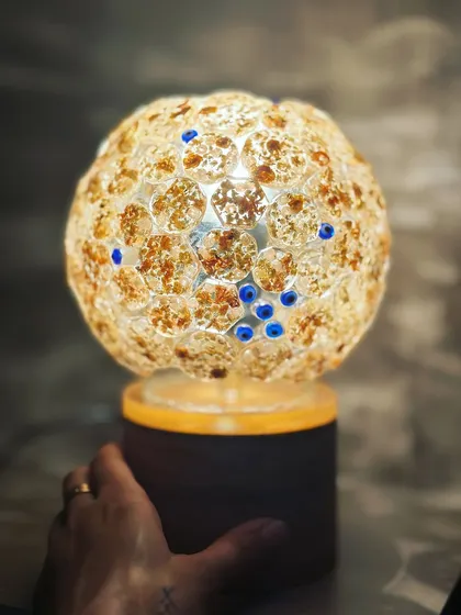 Holding the glowing globe lamp. The warmth and light it gives off is so comforting, filled with happy memories.