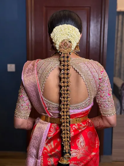 A traditional South Indian bridal hairstyle is a work of art. This classic braid, adorned with intricate temple jewelry and fresh jasmine flowers, is designed to hold perfectly through a long day of ceremonies.