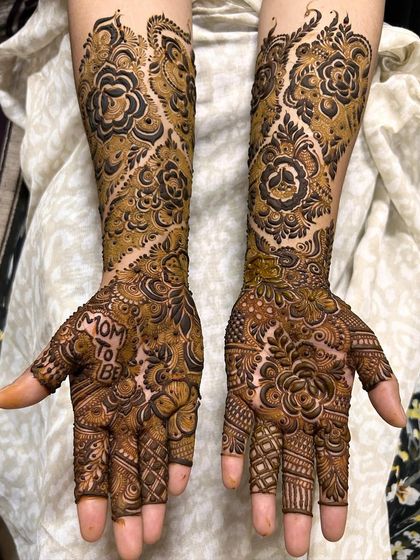 This 'Mom to be' mehendi features a beautiful vine pattern that flows up the arm, combined with intricate work on the palm.