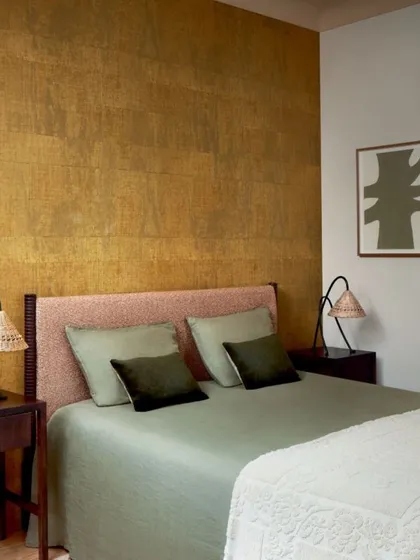 Our wallcoverings go beyond aesthetics, offering a unique blend of texture, color, and design. This gold-toned textured wallpaper adds warmth and a touch of glamour to create a backdrop that elevates this serene bedroom.