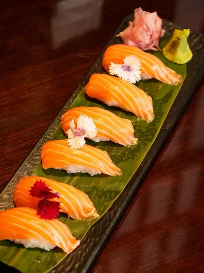 A full platter of our elegant Salmon Nigiri, garnished with edible flowers. It is a simple, classic dish that showcases the quality of our ingredients.