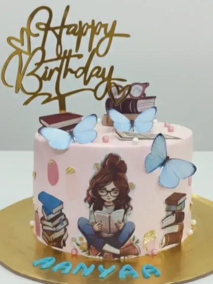 A beautiful cake for a book lover. This chocolate truffle cake is decorated with a girl reading, stacks of books, and butterflies for a whimsical touch.
