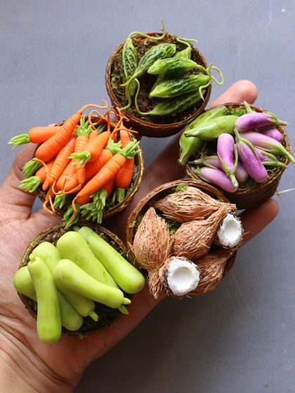 A handful of my miniature vegetable baskets, including carrots, brinjal, and coconuts.