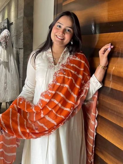 An off-white chanderi viscose kurta paired with a bright orange leheriya dupatta. It's a classic combination that's perfect for celebrating any festival.