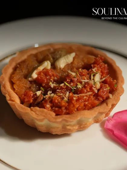 A close-up of a Gajar Halwa tart, a creative fusion dessert that combines a traditional Indian sweet with a contemporary pastry form. We love to innovate while honouring classic wedding flavours.