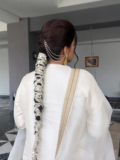 Another angle of the stunning bridal parandi braid. The detailed silver work on the accessory is clearly visible, showcasing a traditional yet glamorous look.