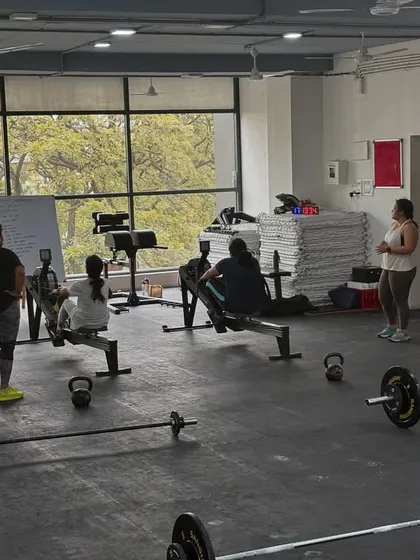 Another view of a typical class in session. You can see members working through different parts of the workout, from rowing and kettlebell exercises to barbell work, all in a supportive group setting.