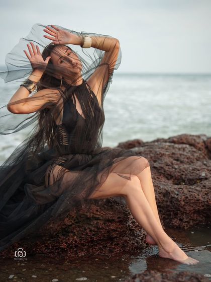 A close-up shot of the model wrapped in the sheer black fabric, creating a mysterious and artistic portrait.