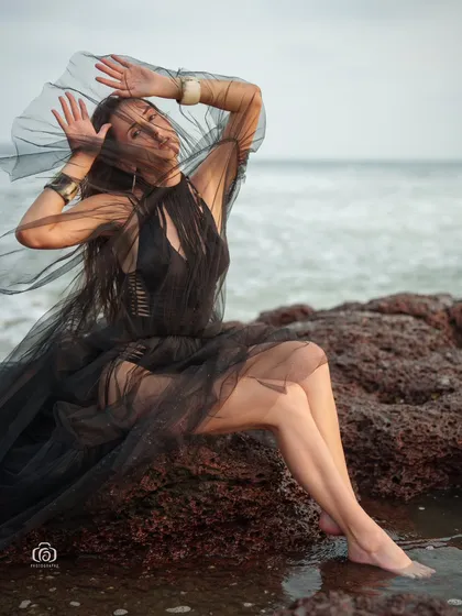 A close-up shot of the model wrapped in the sheer black fabric, creating a mysterious and artistic portrait.