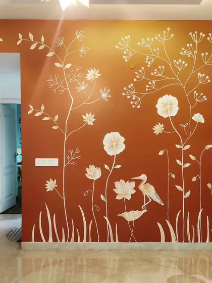 A warm, earthy background makes the white floral textures pop in this Bangalore home. This piece shows how a custom color palette can be used to create a 3D wall mural that perfectly complements the existing decor and pooja space.