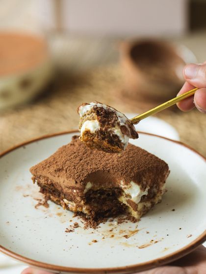 The perfect bite of Tiramisu on a golden spoon, ready to be enjoyed.