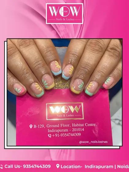 A fresh and fun design for sunny days. This look features a modern French manicure with multi-colored pastel tips and delicate, hand-painted daisies.