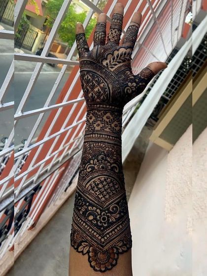 A full-arm bridal design with dark, intricate patterns. This classic Indian mehendi style provides complete coverage for a dramatic and traditional look.