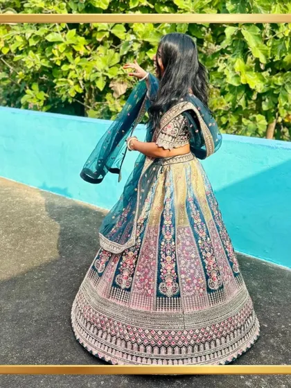 A client showing the beautiful twirl of her dark teal floral lehenga.