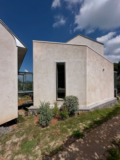 A detail of the 'Wildgrass' home, showing the connection between two volumes. The design breaks down the mass of the house into smaller, interconnected parts that respond to the sloping terrain.