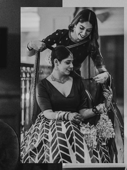 Another angle of the bride getting ready with her sister or bridesmaid, a beautiful moment of connection captured in timeless black and white.