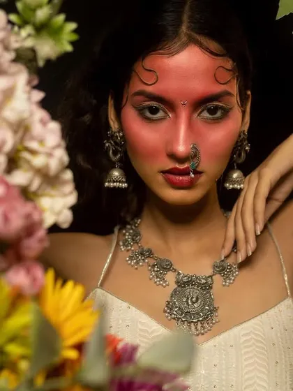A creative editorial makeup concept where I used a vibrant red pigment across the face. This look, framed by flowers, demonstrates my ability to execute artistic and unconventional briefs for fashion photoshoots.