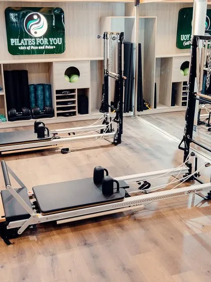 Welcome to my Hauz Khas studio. It's a clean, calm, and modern space filled with top-of-the-line equipment, including Reformers and Trapeze Towers, designed to be your sanctuary for self-care and focused movement.