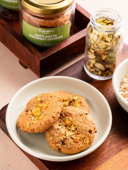 Three of my Oats & Aata Cookies served on a simple white plate. Made with wholesome oats and nutty whole wheat flour, these are the perfect comfort snack to go with your evening chai.