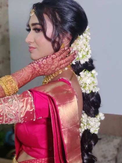 A side view of Ankita's wedding look, featuring a traditional long braid adorned with fresh jasmine flowers.
